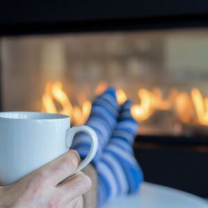 image of a person drinking cocoa in front of a fireplace