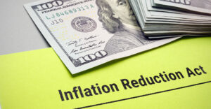 Image of a paper next to some money the title is Inflation Reduction Act